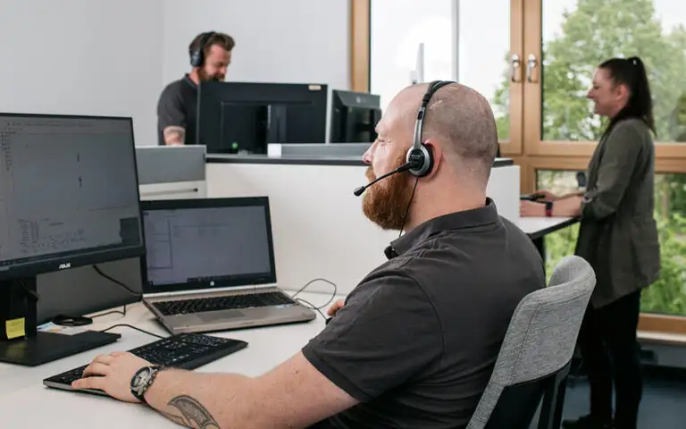 Techniker am PC mit Headset hilft telefonisch und online bei Fragen zu Lasersystem und Magic Mark