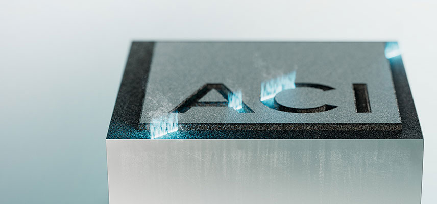 Lasergravur des ACI Logos auf einem Metallblock