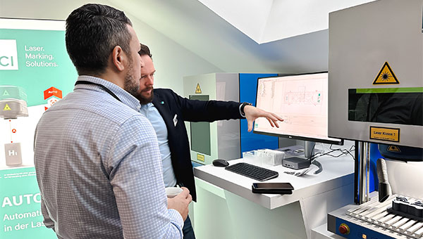 Consultation between ACI employee and customer in front of laser marking system