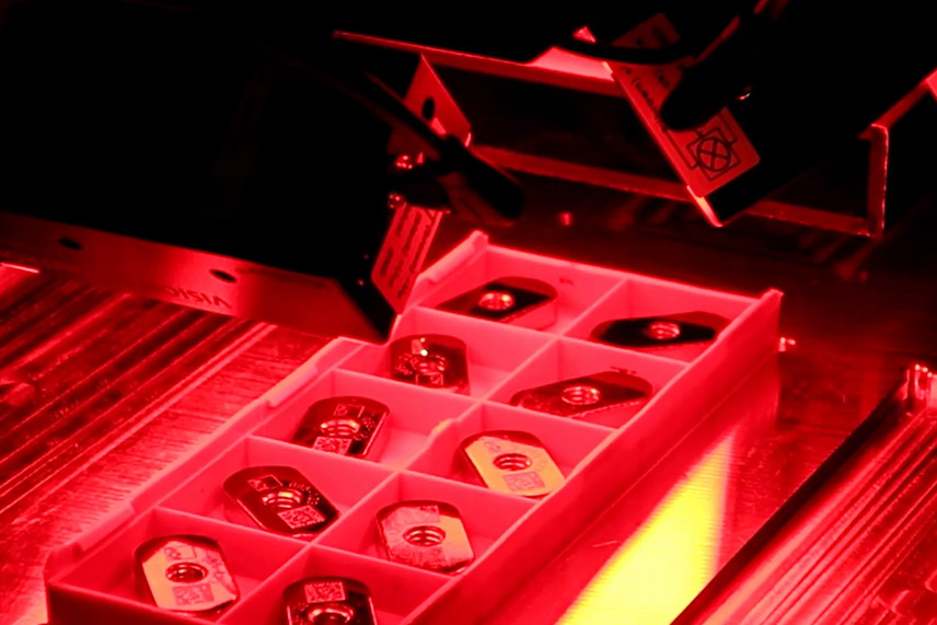 Rot ausgeleuchtete Nestaufnahme einer Lasermarkierstation mit AOI-Vision-System zur Bauteilkennzeichnung per Laser