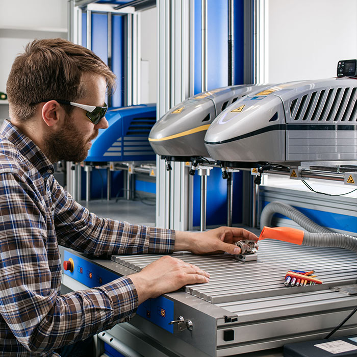 Applikationstechniker im Labor: Beginn der Musterteil-Beschriftung mit Materialtests