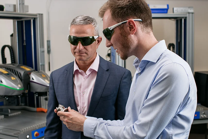 ACI Laser application consultation in the laboratory - employee and customer inspect manufactured sample part