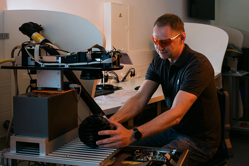 ACI Laser Quality Assurance - Employees inspecting a laser system