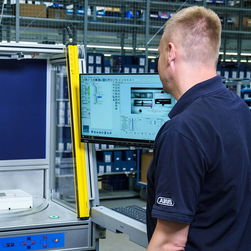 System operator looks at the PC screen of a laser station in a production hall