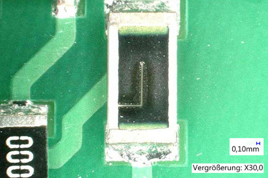 Lasergetrimmter L-Cut auf SMD-Widerstand einer Leiterplatte bei 30-facher Vergrößerung
