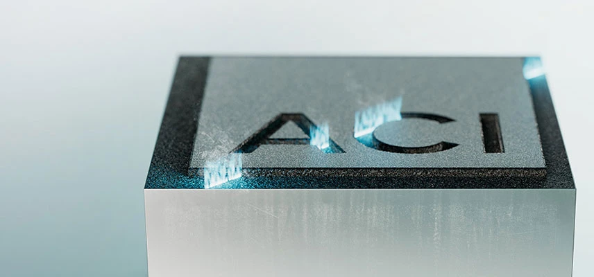 Laser engraving of the ACI logo on a metal block