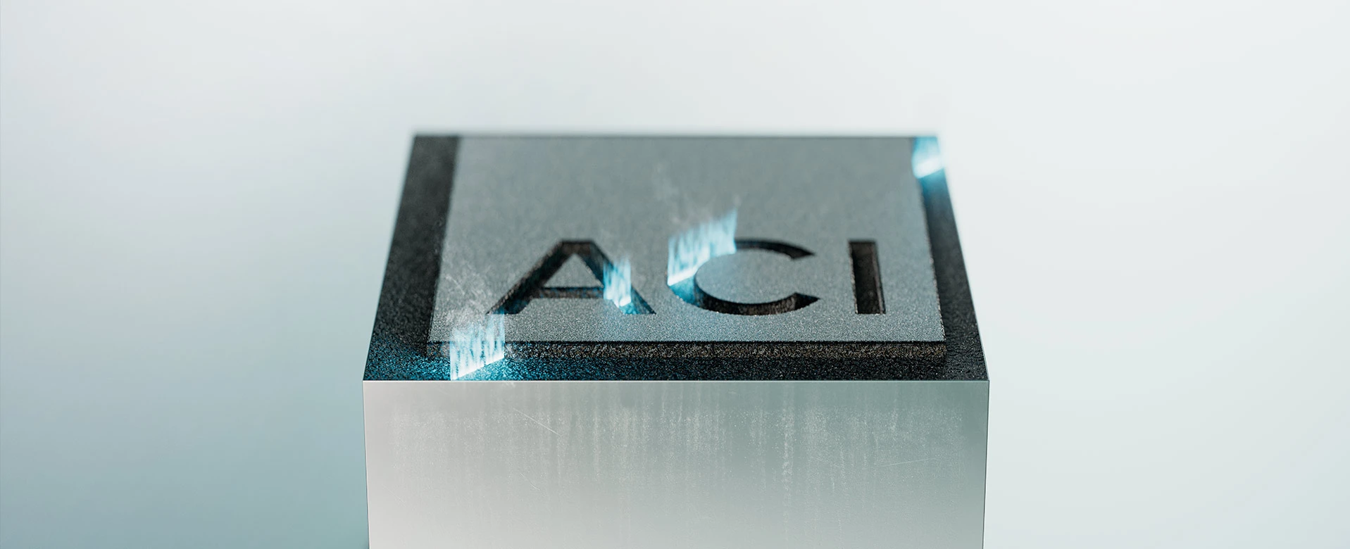 Engraved metal block with ACI laser logo - symbol of precision and quality