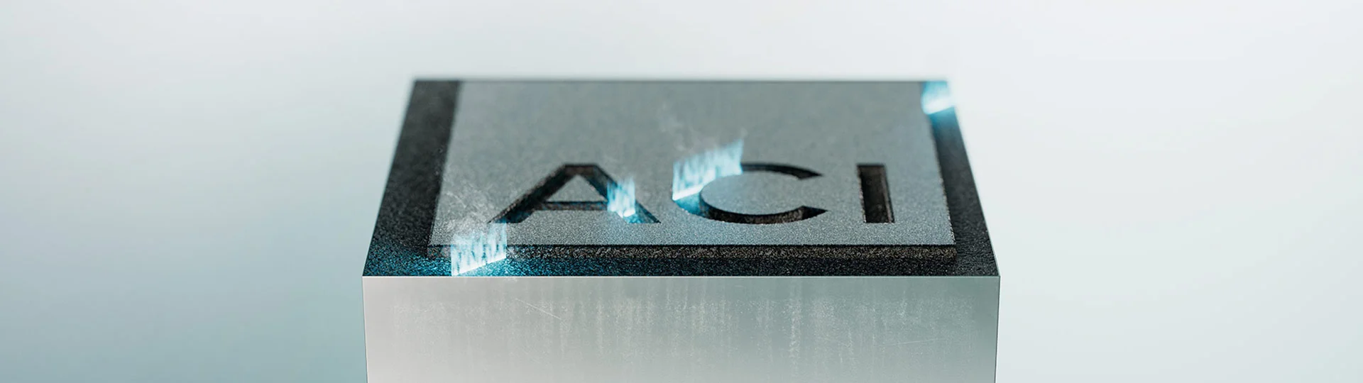 Engraved metal block with ACI laser logo - symbol of precision and quality