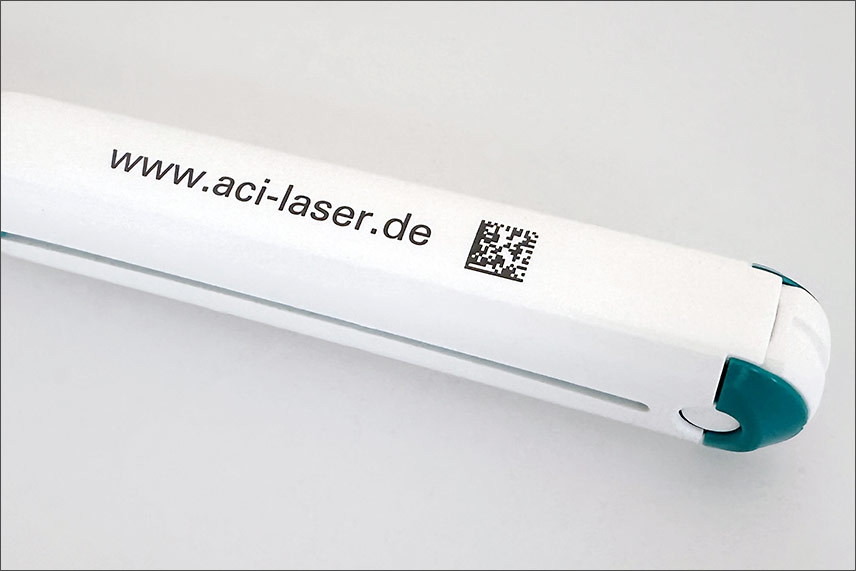 Black laser marking with text and DMC on white plastic produced with a UV laser