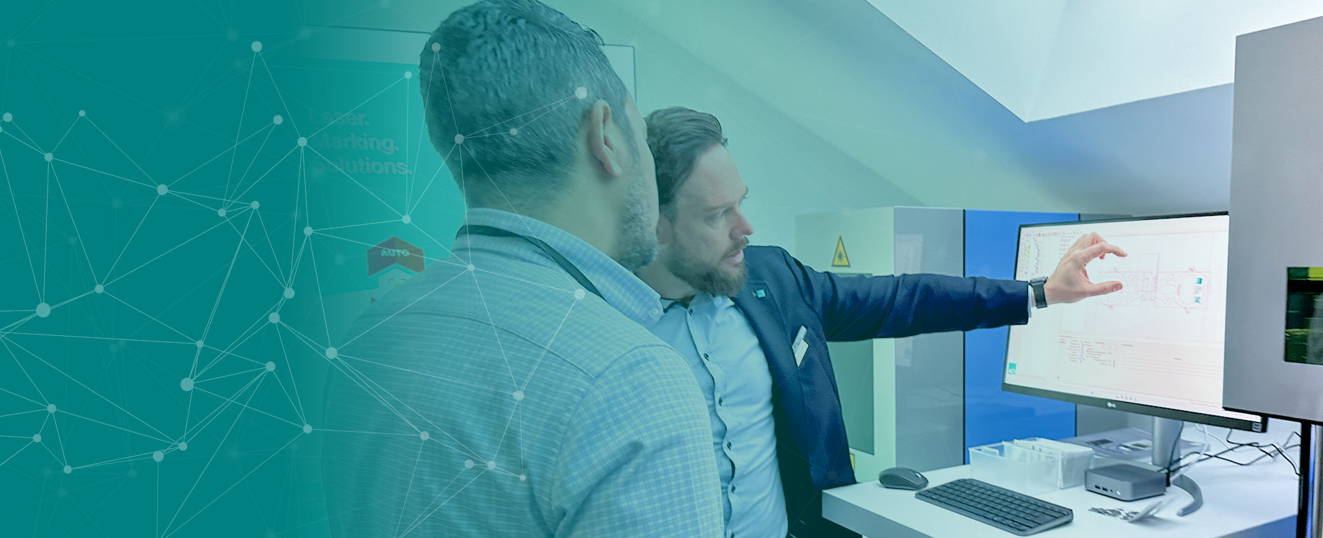 Zwei Personen blicken auf einen PC Monitor