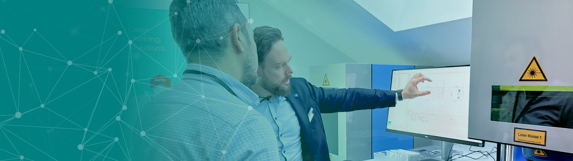 Zwei Personen blicken auf einen PC Monitor